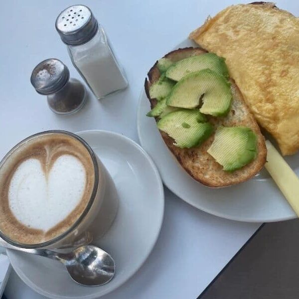 cafe con espuma y tostada de aguacate en la cartuja