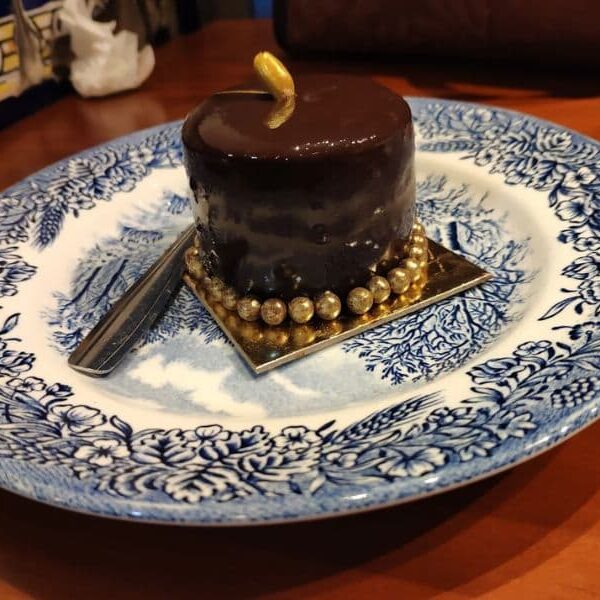 pastel de chocolate pequeño con perlas doradas comestibles