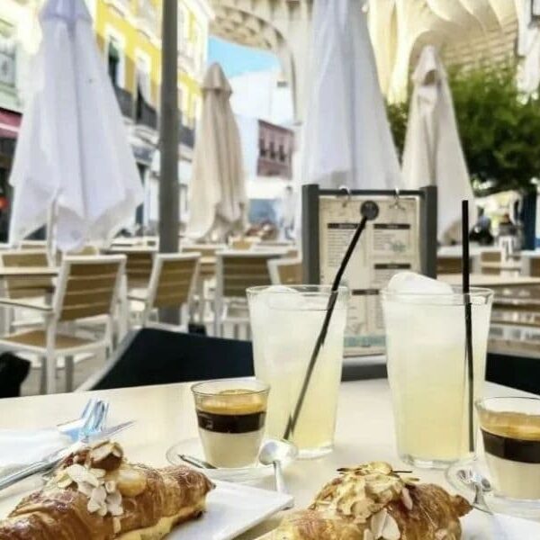 mesa en la terrza con vistas a las setas con croasant y dos cafes zumos